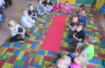 Kilkanaścioro dzieci siedzących w klasie  